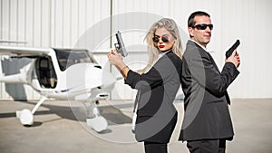 Professional female and male security spy agents posing with guns