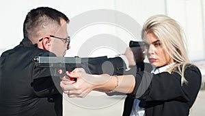 Professional female and male security spy agents posing with guns