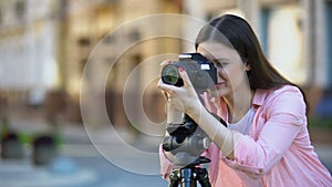 Professional female photographer focusing camera objective, photo shooting