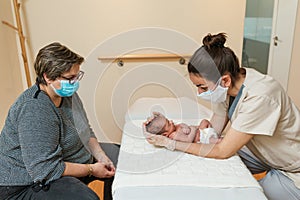 Professional female physiotherapist performing parietal work and lambdoid suture on a newborn.