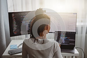 Professional female programmer working on new project on computer at home, back view