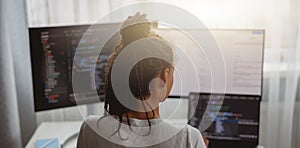 Professional female programmer working on new project on computer at home, back view