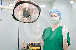 Professional female surgeon wearing surgical gown and gloves in operating room.