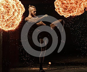 Professional fighter shadowboxing with fire and sparks on background
