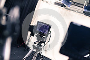 Professional film camera with lcd screen on a tripod in broadcasting studio