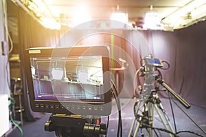 Professional film camera on tripod, broadcasting studio, spotlights and other recording equipment