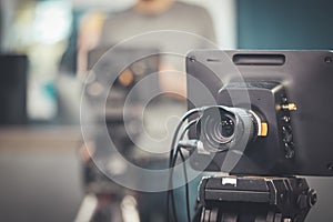 Professional film camera on tripod, broadcasting studio, spotlights and other recording equipment