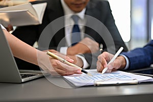 Professional financial Analysts team having a formal meeting. pen pointing on paper. close-up