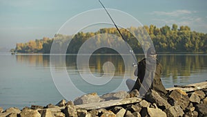 Professional fisherman fishing on river bank, float close-up, rod and tackle