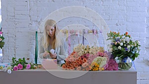 Professional florist making gift box with flowers at flower store