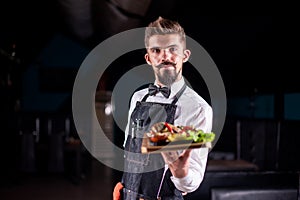 Young garcon serves dish at a festive event. photo