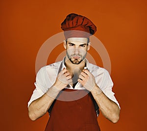 Professional food preparation concept. Man in cook hat and apron