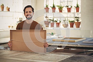 Professional framer in his studio workshop smiling