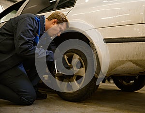 Professional garage mechanic repair the leaky tire car wheels. Car engineer technician changing a car tire on a vehicle. Concept