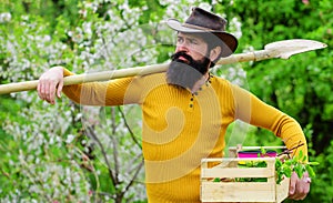 Professional gardener in garden with gardening tools. Bearded man in hat with shovel. Spring work.