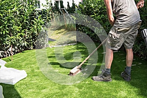 Professional gardener puts sand on artificial turf