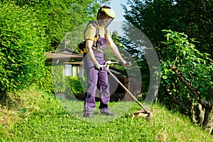 Professional gardener using an edge trimmer in home garden