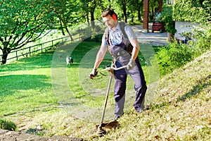 Professional gardener using an edge trimmer in home garden