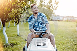Professional gardener worker using lawn tractor