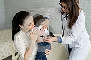 Professional general medical pediatrician doctor in white uniform gown listen lung and heart sound of child patient with