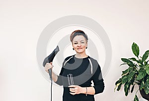 Professional girl hairdresser with hairbrush hair dryer in hand on white background
