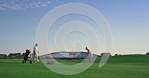 Professional golf people play game on fairway. Couple practice on sunset course.