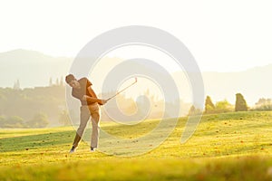 Professional Golfer asian man swing and hitting golf ball practice at golf driving range and fairway in sunny morning day on club
