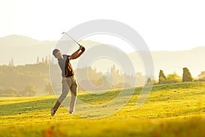 Professional Golfer asian man swing and hitting golf ball practice at golf driving range and fairway in sunny morning day on club