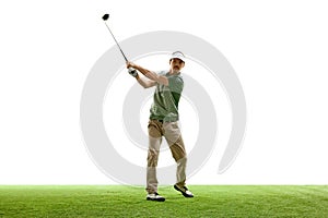 Professional golfer in casual attire in mid-swing with driver on artificial turf against white studio background.