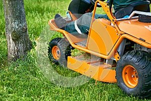 Professional grass cutting on lawns with a mini tractor lawn mower.