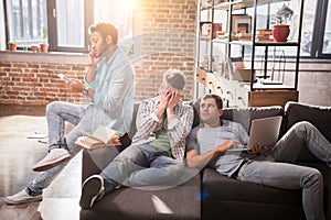 Professional group sitting together on sofa with laptop and discussing