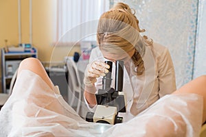 Professional gynecologist examining her female patient on a gynecological chair