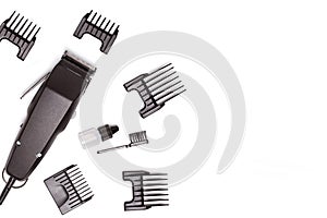 Professional hair clipper with set of nozzles of different sizes isolated on white background. Top view