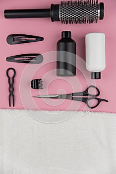 Professional hair dresser tools with copy space. Hair stylist equipment set on pink background.