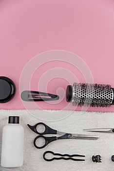 Professional hair dresser tools with copy space. Hair stylist equipment set on pink background.