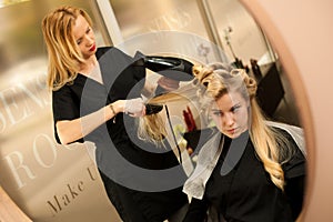 Professional hair stylist at work - hairdresser doing hairstyle