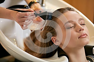 Professional hairdresser in beauty saloon with clients
