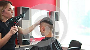 Professional hairdresser drying hair in beauty salon.