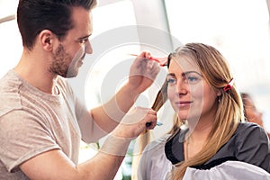 Professional hairdresser dyeing hair of her client