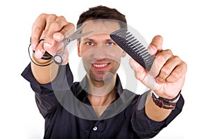 Professional hairdresser holding scissors and comb