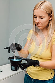 A professional hairdresser mixes a dye with an oxidizer. Hair coloring