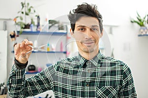 Professional hairdresser with scissors at barbershop.