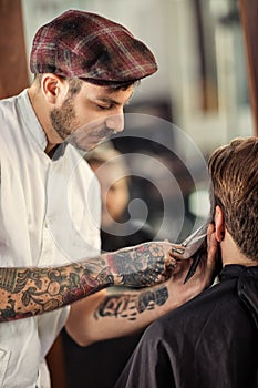 Professional hairdresser with scissors cut the beard