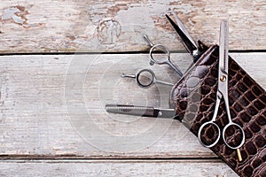 Professional hairdresser scissors on wooden background.