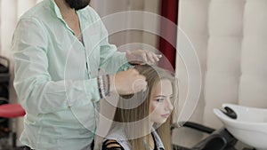 Professional hairdresser styling combing model hair. Making volume hairstyle