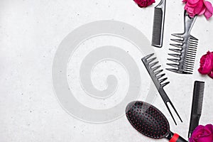 Professional hairdresser tools with red flowers on white background, copy space