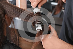 Professional hairdresser working with client in beauty salon, closeup