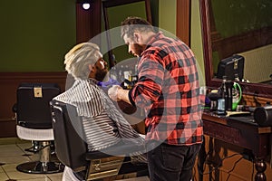 Professional hairstylist in barbershop interior. Portrait of stylish man beard. shaving. Hairstylist in barbershop. man