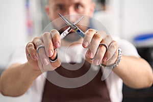 Professional hairstylist posing for camera and crossing scissors