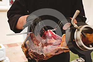 Professional ham carver cutting cured ham slices.